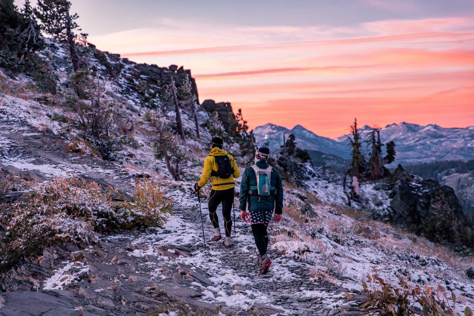  Two runners hiking up to Ellis Peak at sunrise with a dusting of snow on the ground 