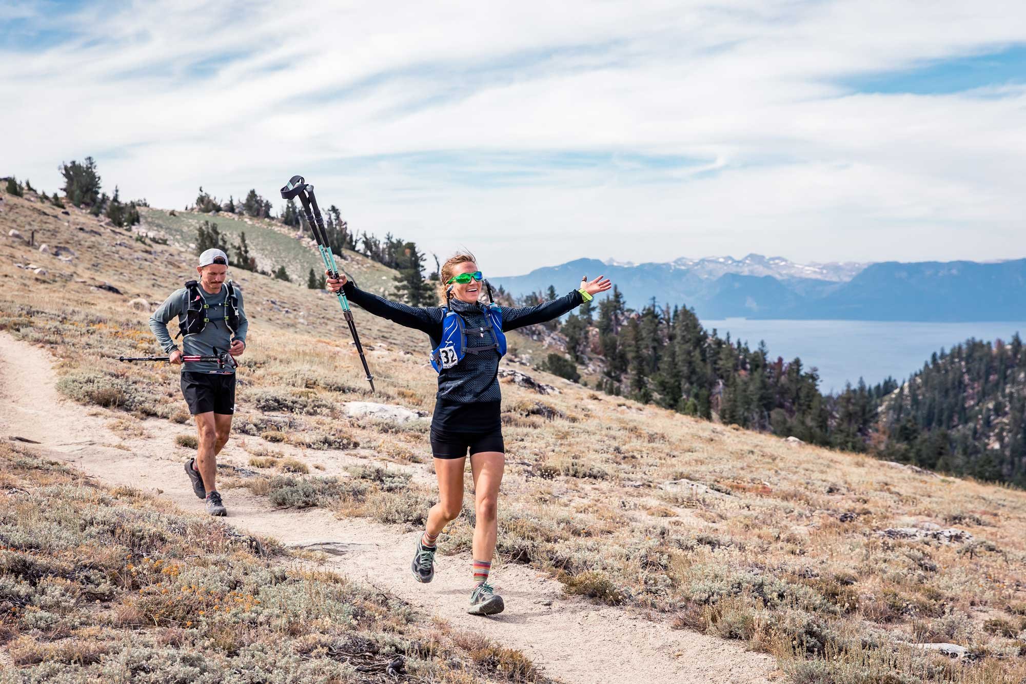  A male and female runner at Tahoe 200 running through Snow Valley  having fun 