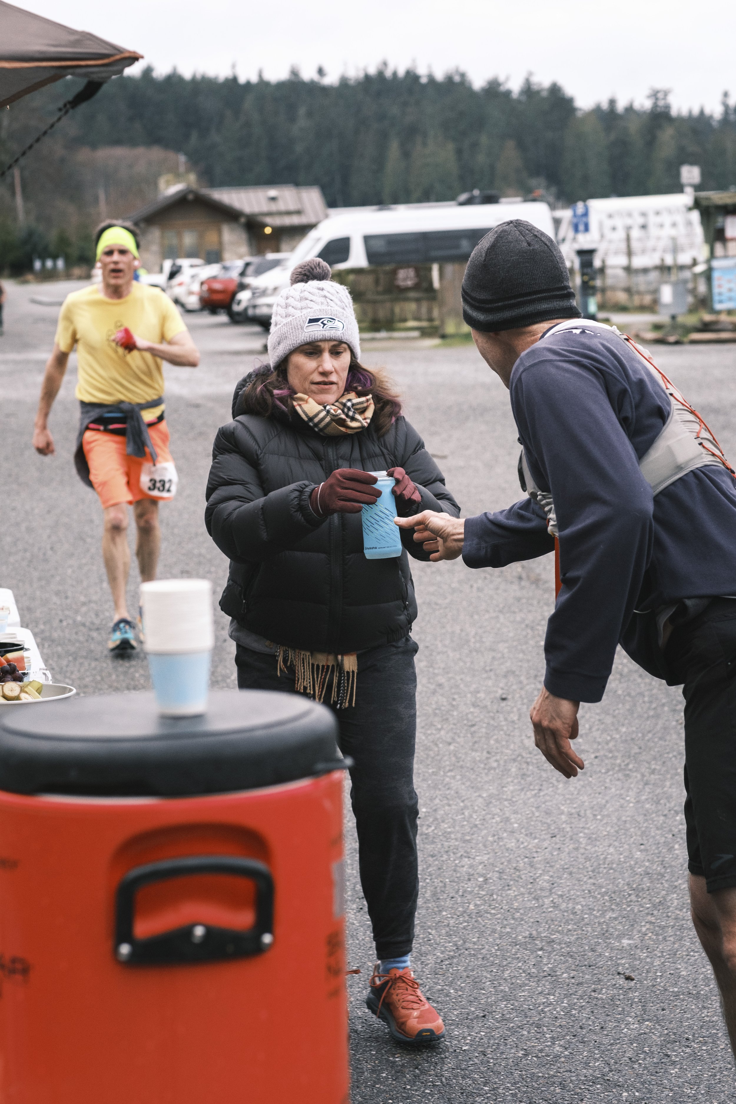 volunteers helping a runner at an aid station