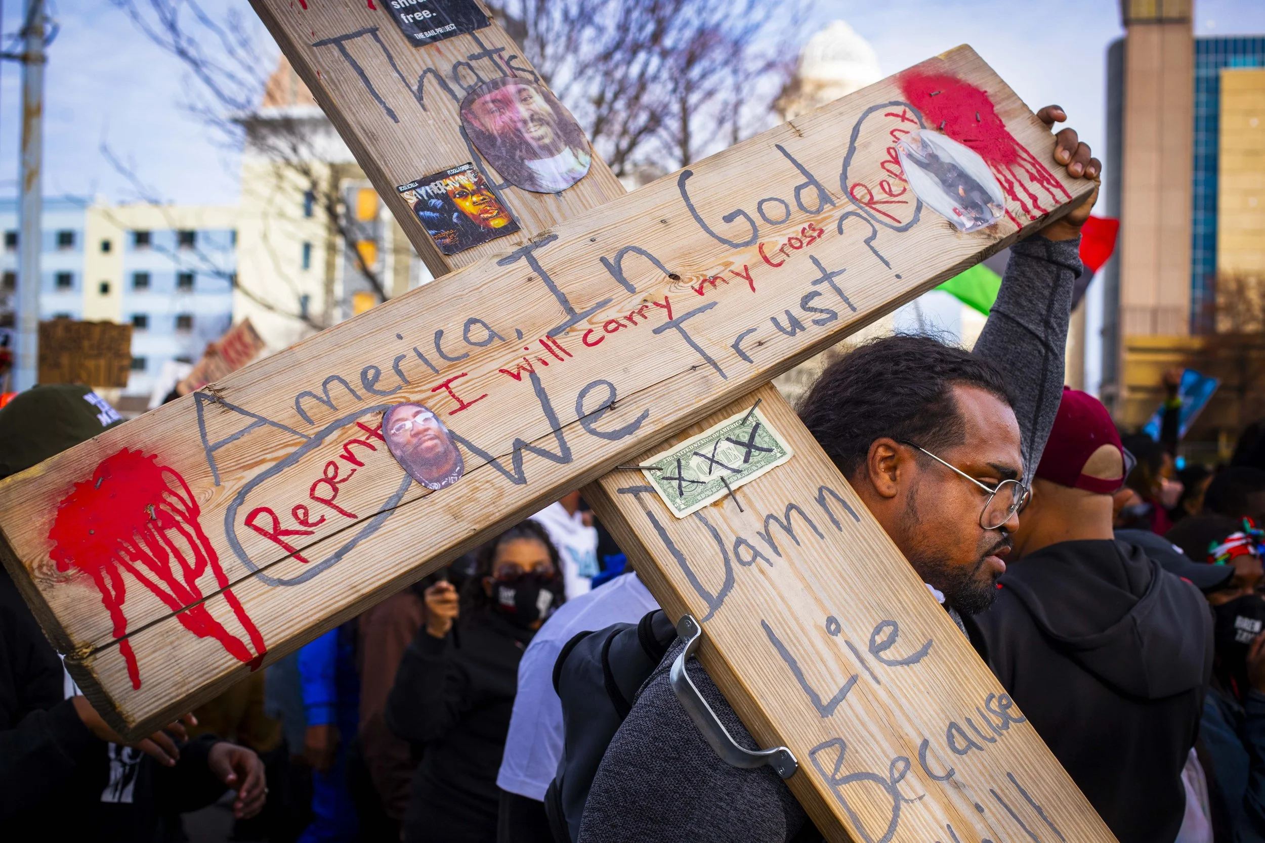 A protesters bears a cross during a march through downtown Louisville marking one year since Breonna Taylor’s murder by officers of the Louisville Metro Police Department, on March 13, 2021. 