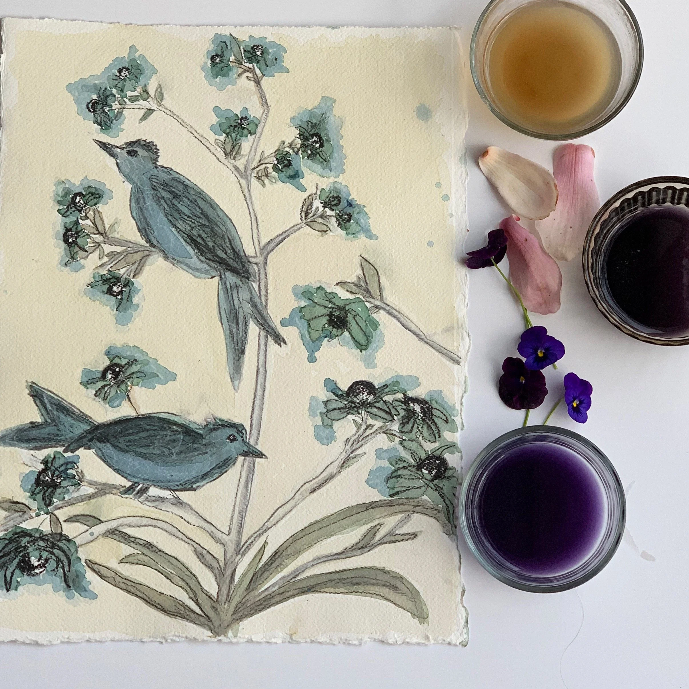 A watercolor painting of two birds perched on a flowering branch, surrounded by purple and pink flower petals, with three glasses of wine or juice in different colors and a small bunch of purple flowers next to the artwork.