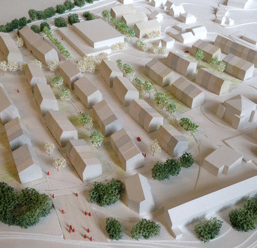 Architekturmodell einer städtischen Bebauung mit Gebäuden, Straßen, Bäumen und kleinen Menschenfiguren, die die Planung einer Wohn- oder Geschäftsanlage darstellen.