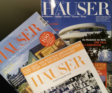 Mehrere Ausgaben des deutschen Magazins HÄUSER, das sich mit Architektur, Design, Kunst und Garten beschäftigt, sind sichtbar. Die Zeitschriftencover zeigen moderne Gebäude und weisen Überschriften über Architekturtrends und ausgewählte Architekten auf.