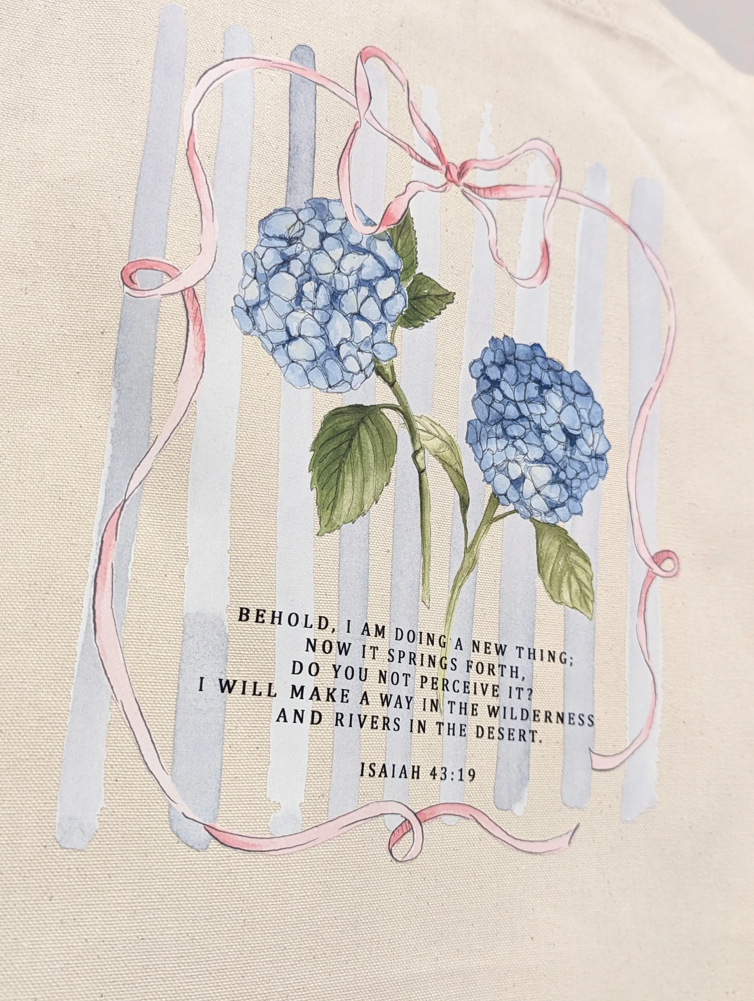 Close up view of our Isaiah 43:19 cotton canvas tote bag with watercolored hydrangea and bow design from Grace Notes Ltd