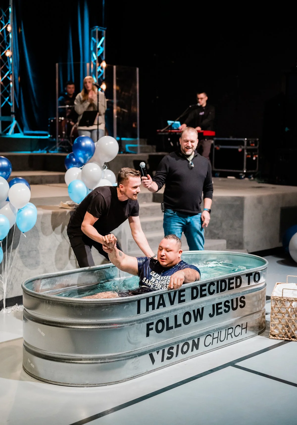 Pastor Boris helping a man out of the water after getting baptized.