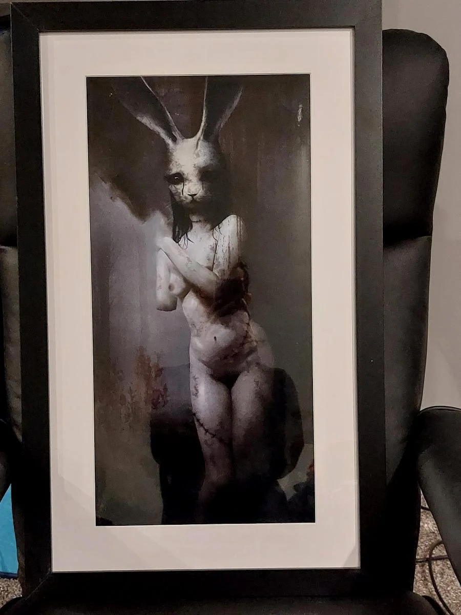 An artwork featuring a humanoid figure with a rabbit's head, painted with a dark and eerie style.