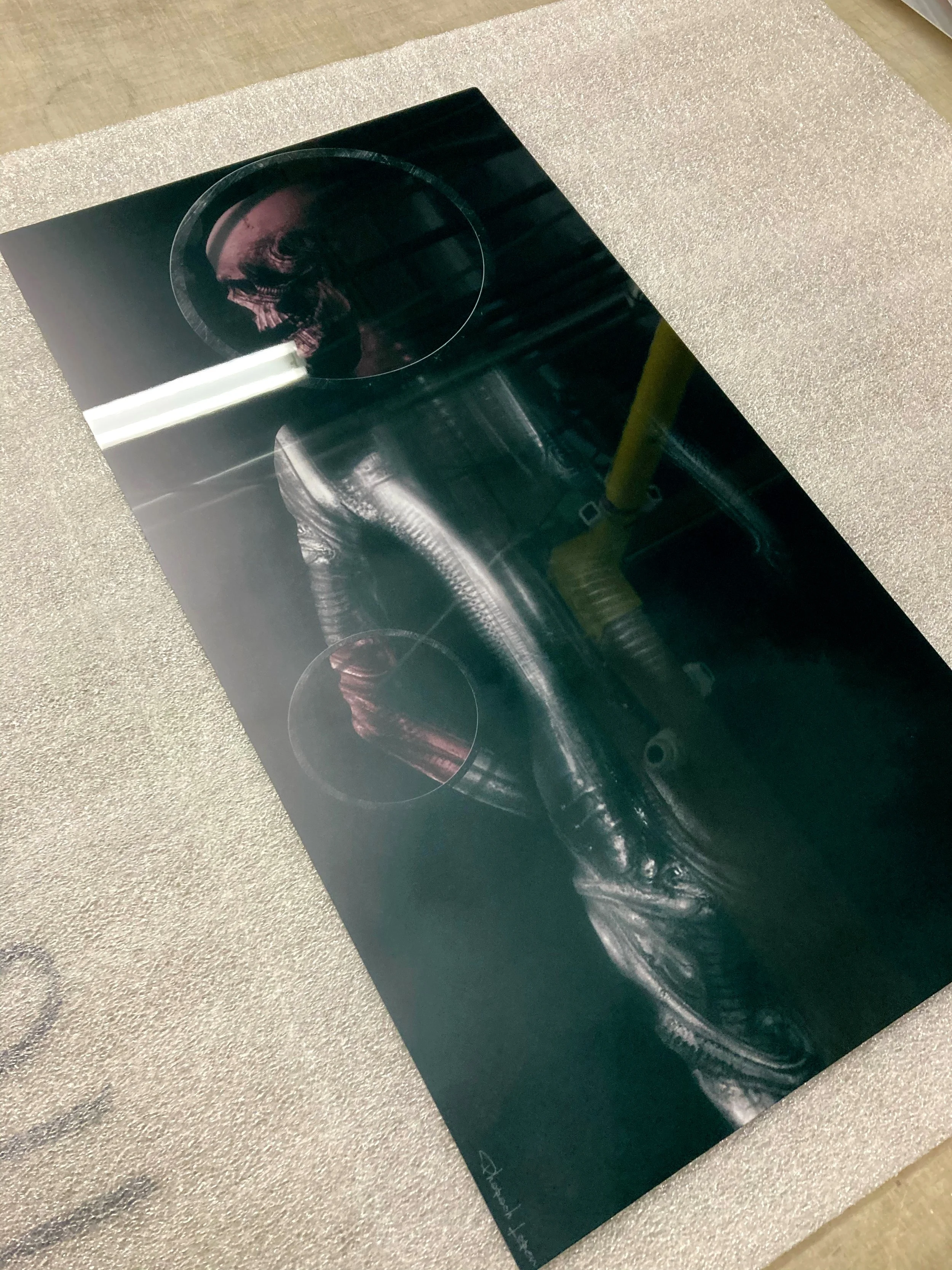 A science fiction poster featuring a humanoid figure wearing a dark helmet, with a reflective metallic suit, standing in a futuristic industrial setting.