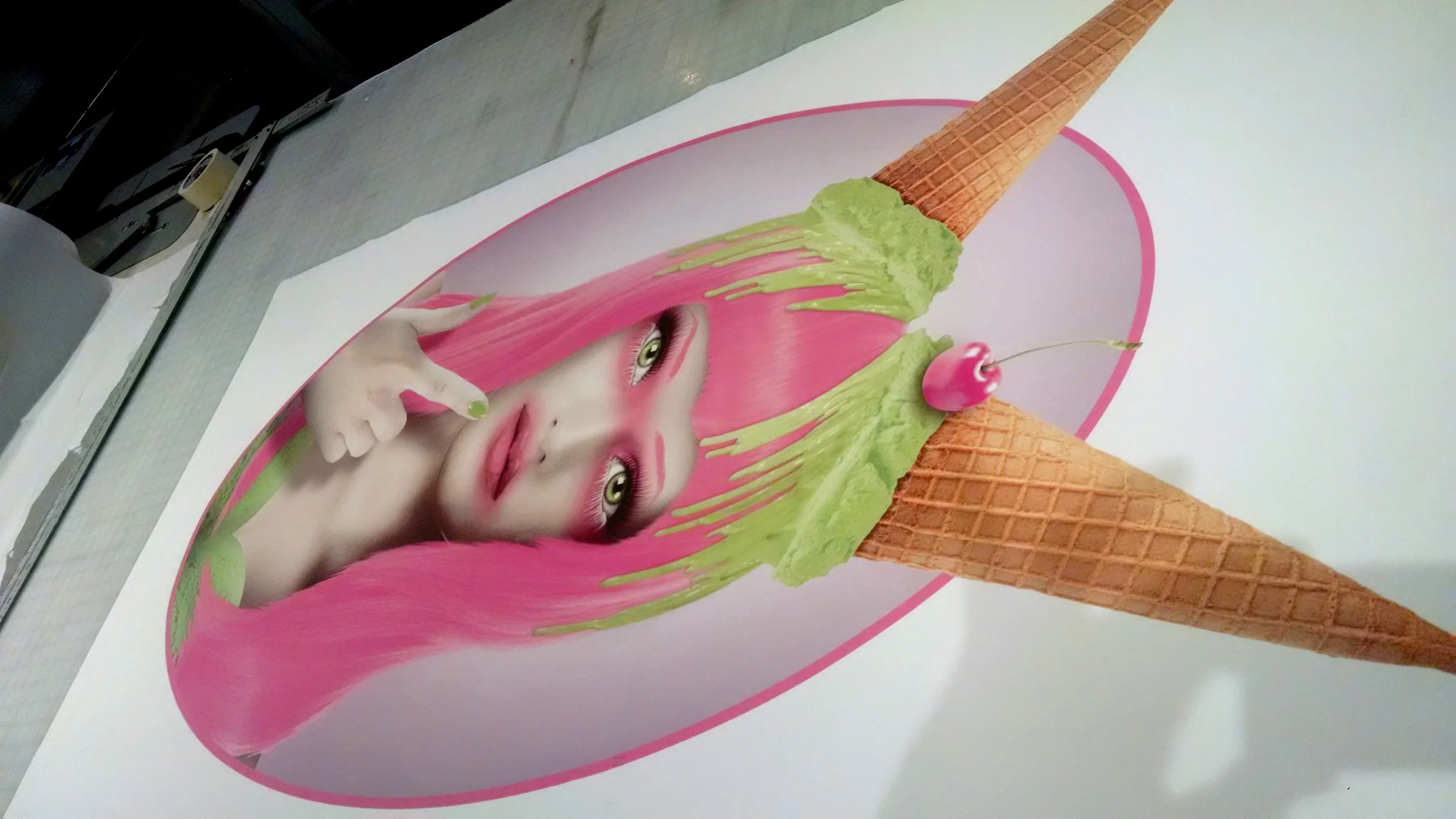 Poster of a surreal woman with pink hair, green eyes, and green makeup, with her finger near her lips, inside an ice cream cone with a cherry on top.