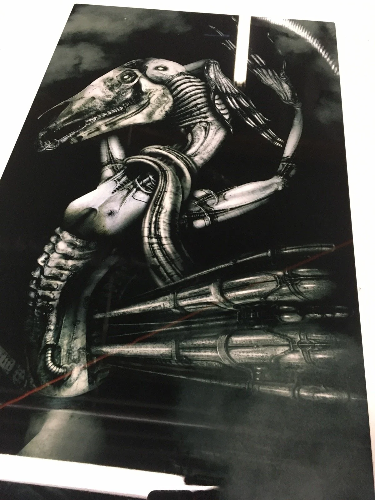 A futuristic, cyberpunk-style artwork featuring a humanoid figure with a skull-like face, mechanical limbs, and a robotic tail, set against a dark background with clouds and stormy elements.