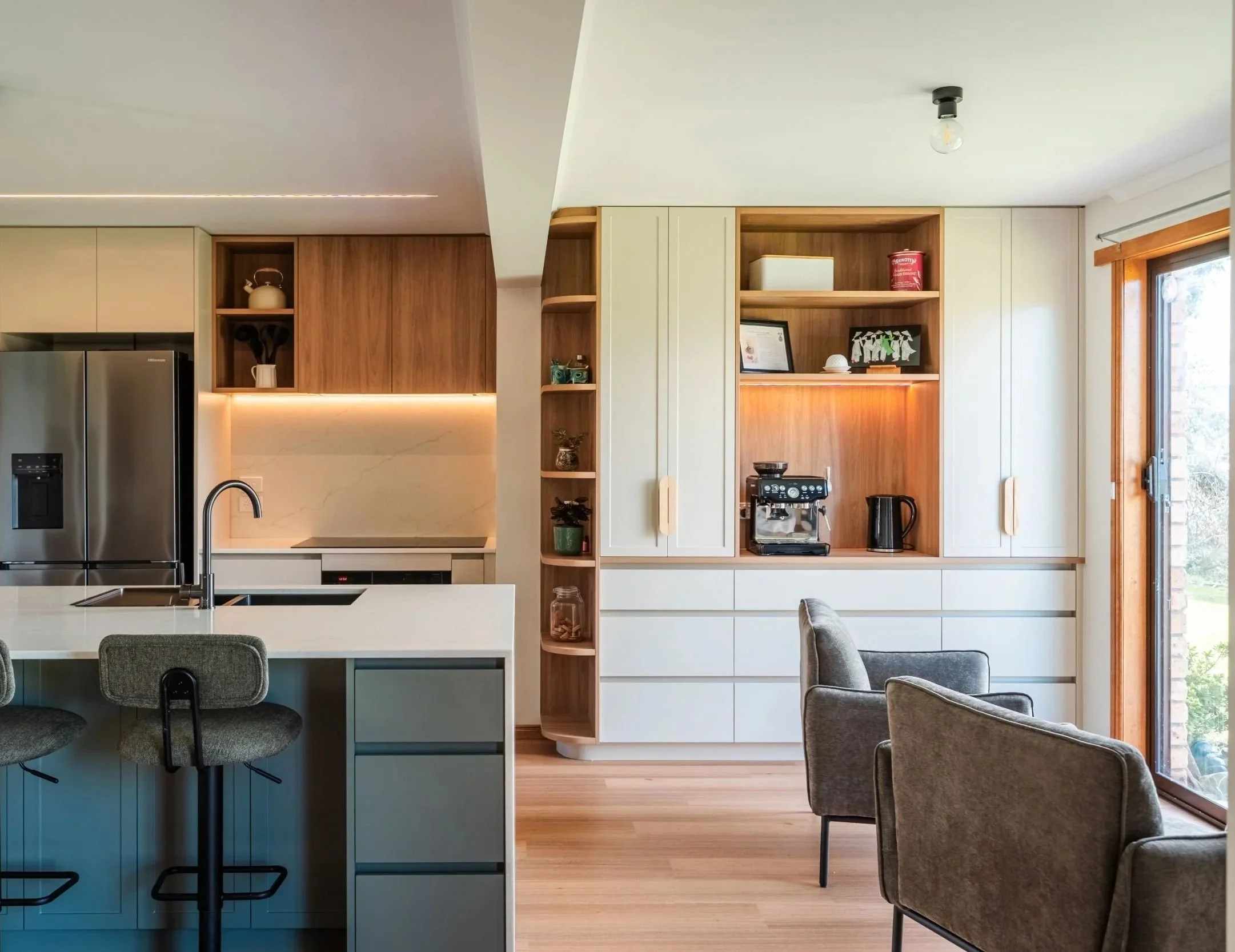 Wide view of the kitchen, island seating and living area beyond