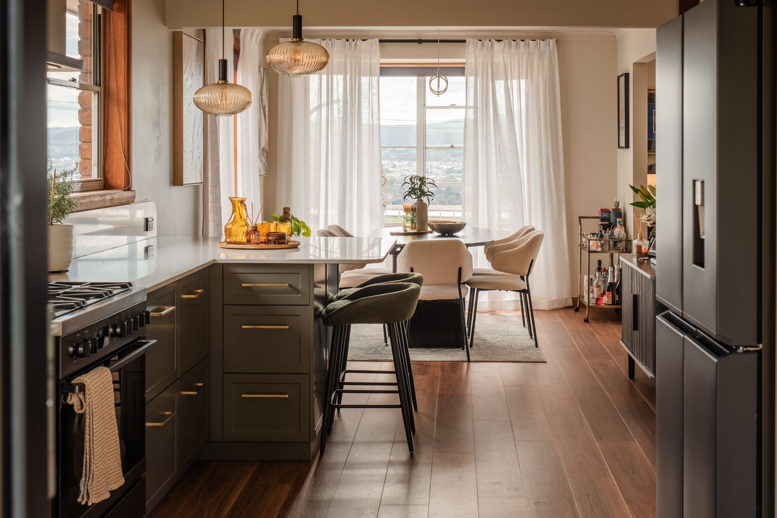 Open plan kitchen looking through to the dining area and sheer curtained windows