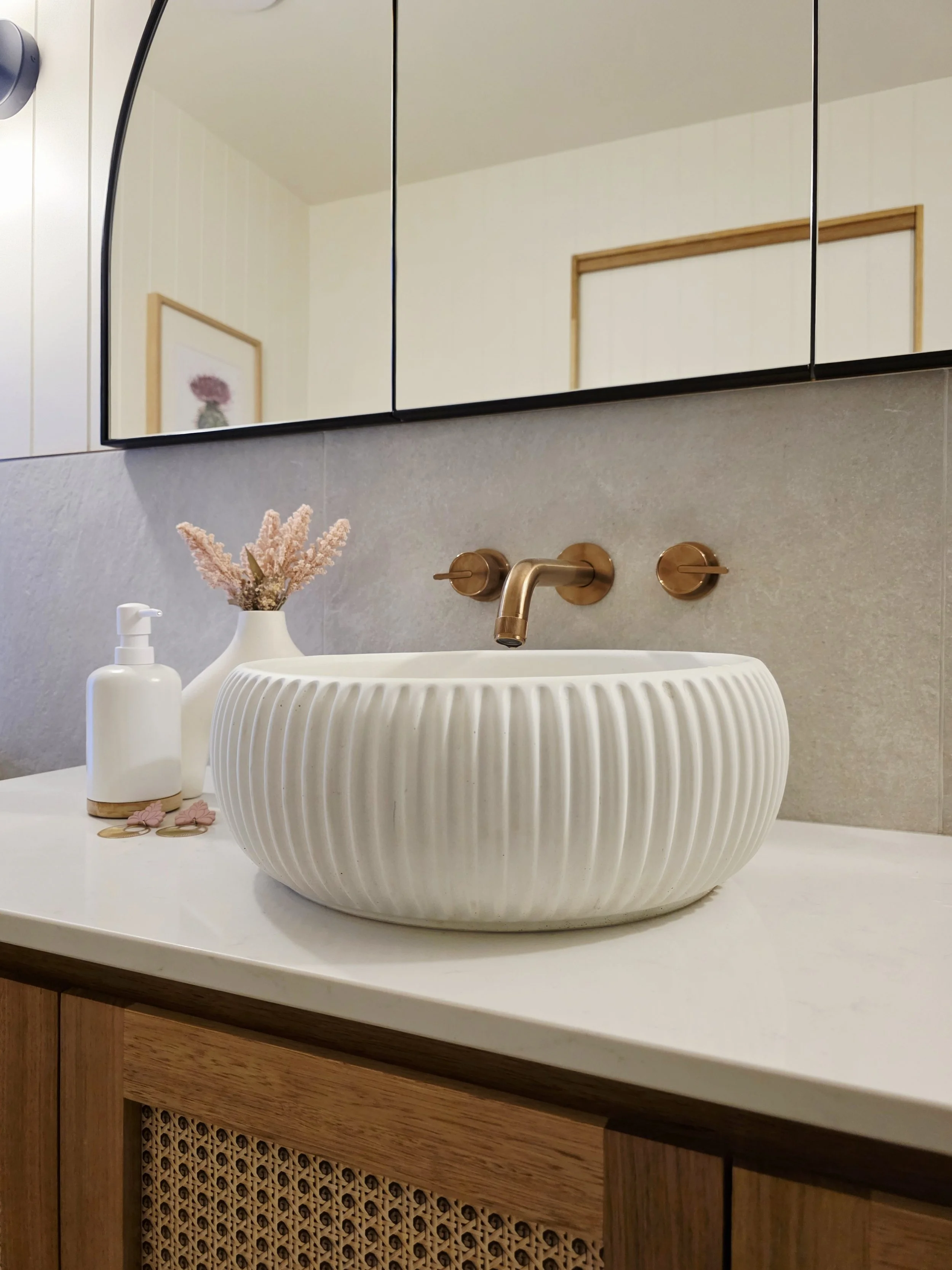 Concrete fluted basin, copper tapware and timber joinery in the ensuite at Raeburn