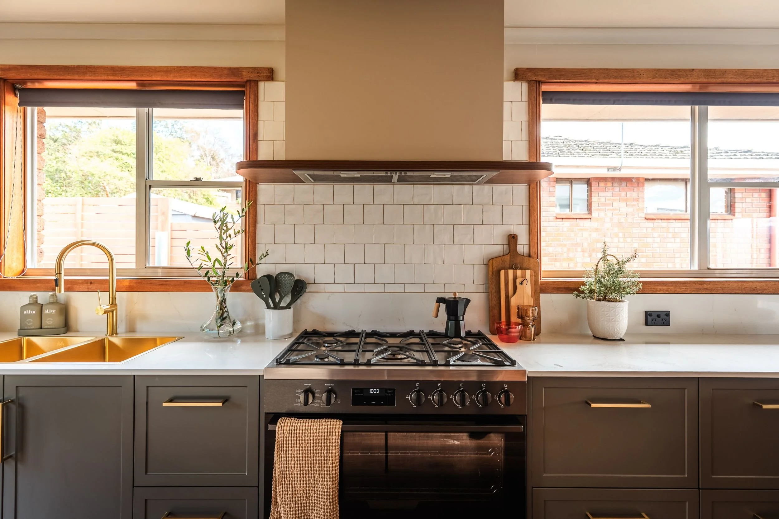 Freestanding gas stove set into dark cabinetry with a tiled splashback