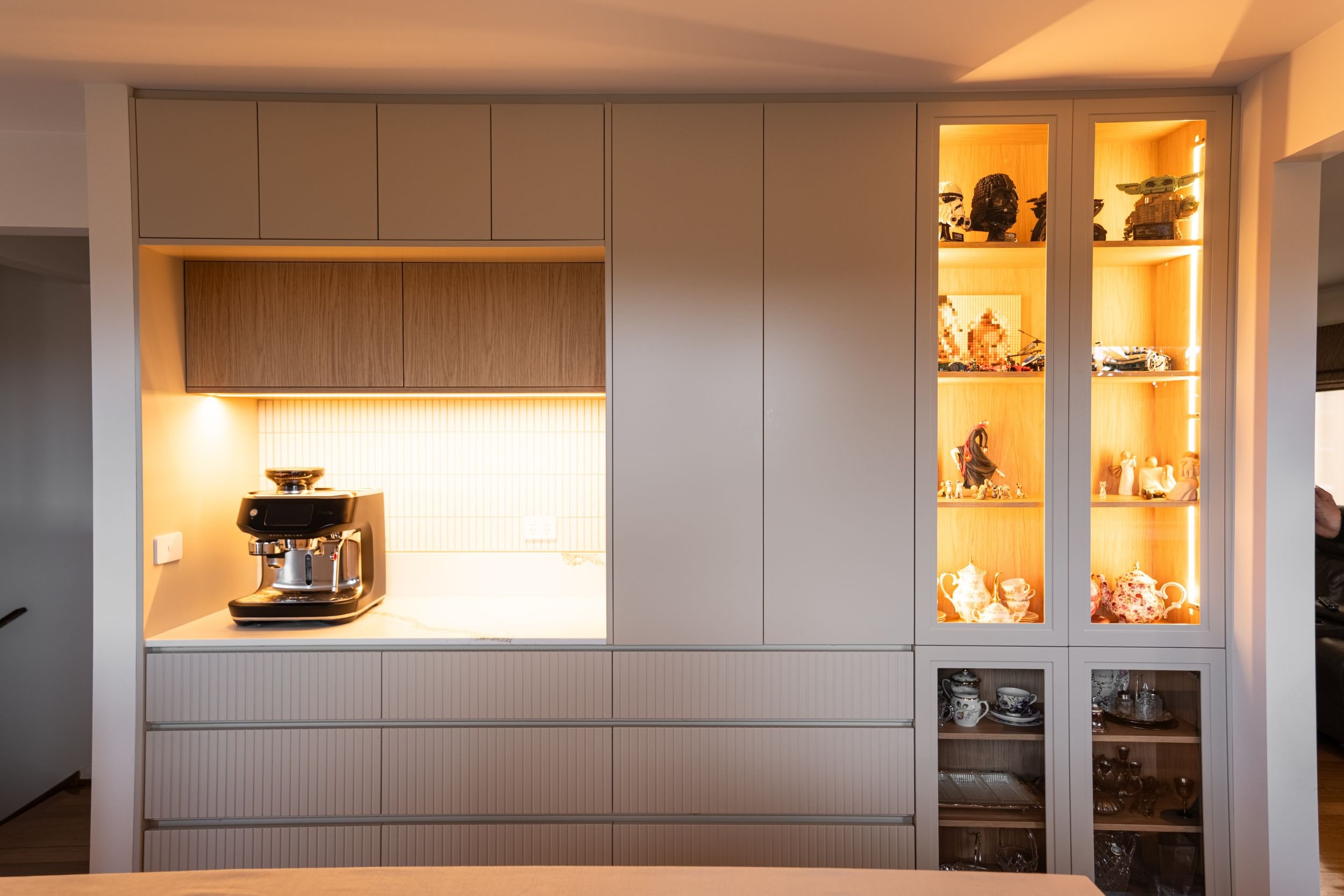 Dining room joinery with a lit coffee station and glass display cabinets