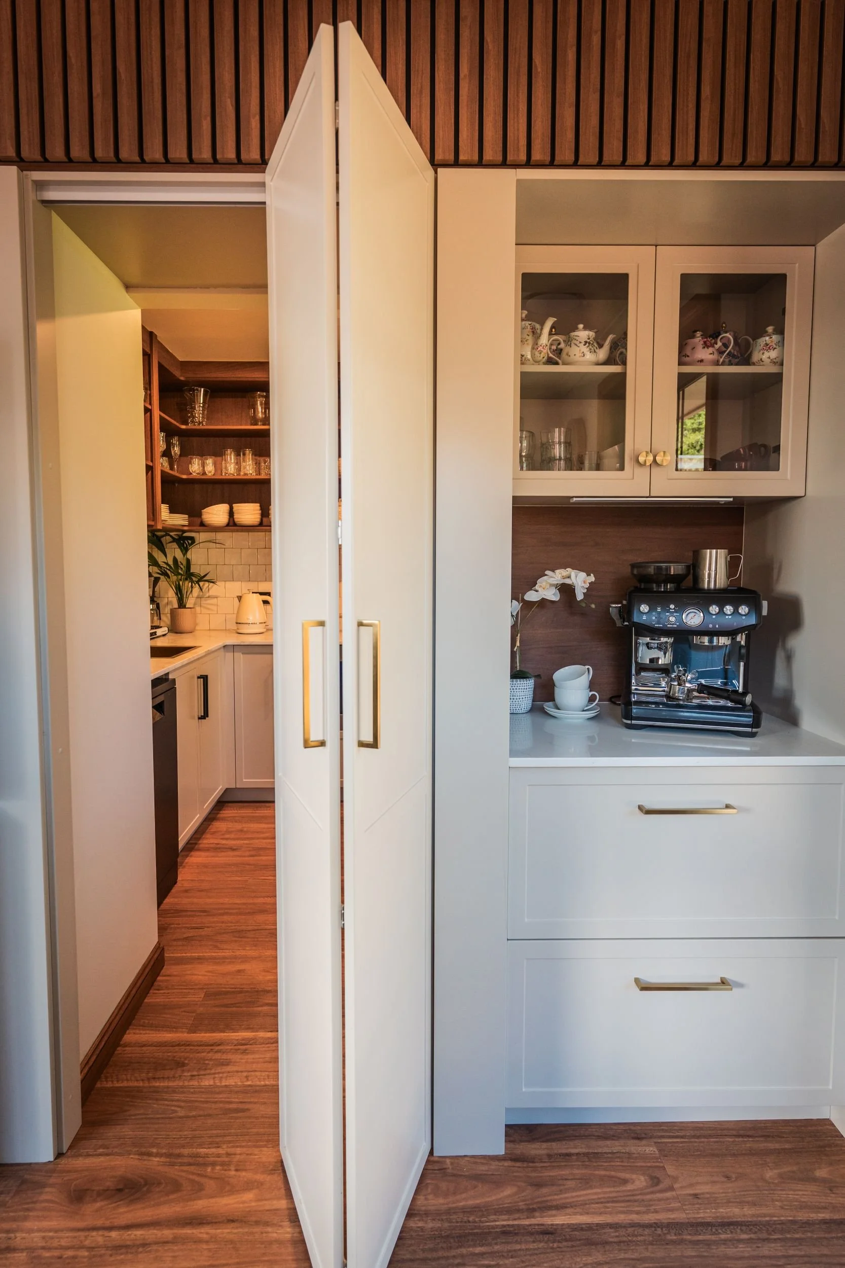 Tall cabinet door opening to reveal a hidden butler's pantry