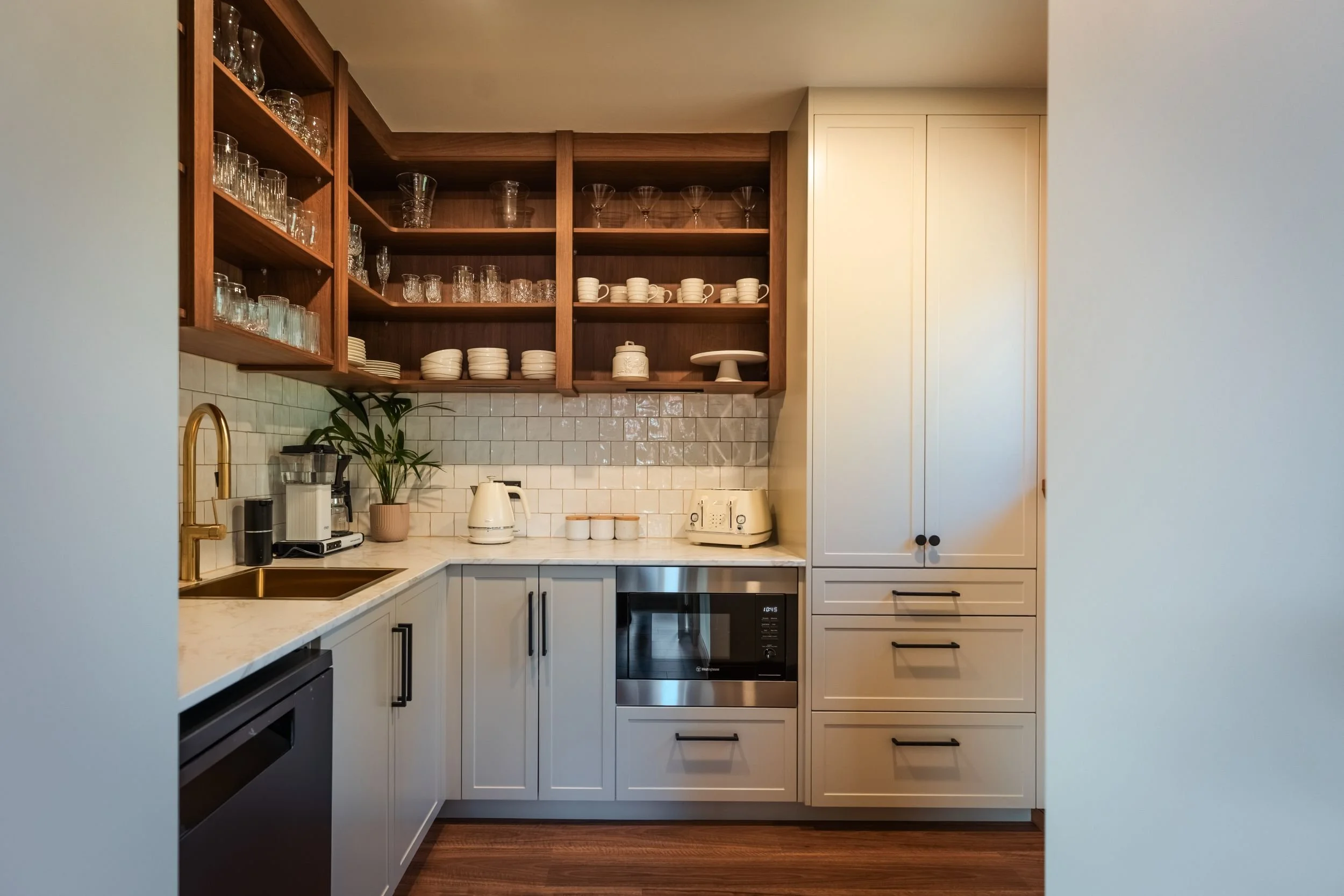 Butler's pantry with open walnut shelving, white tiles and integrated appliances