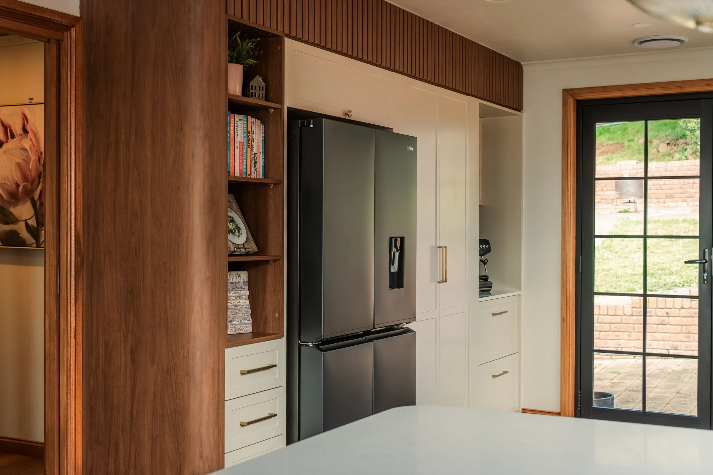 Functional, timber-panelled joinery beside the french doors