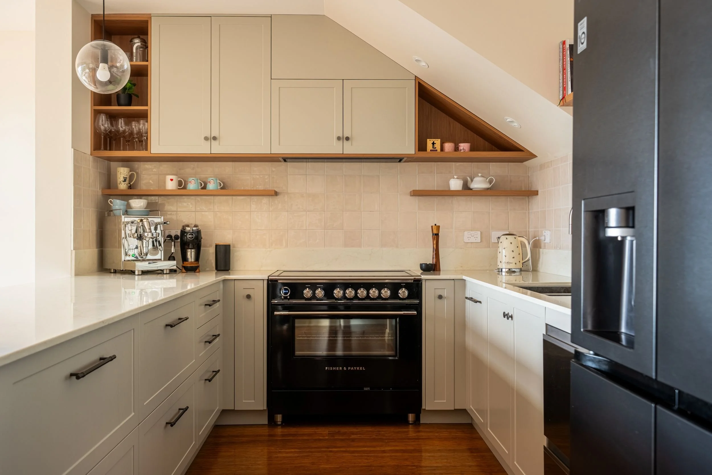 Cooking elevation with black cooker, greige cabinetry and timber shelves