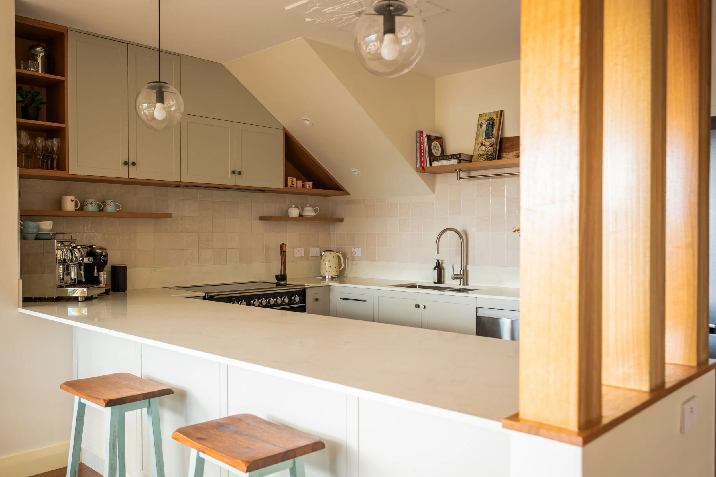 Breakfast bar with timber stools and timber posts dividing the kitchen and dining