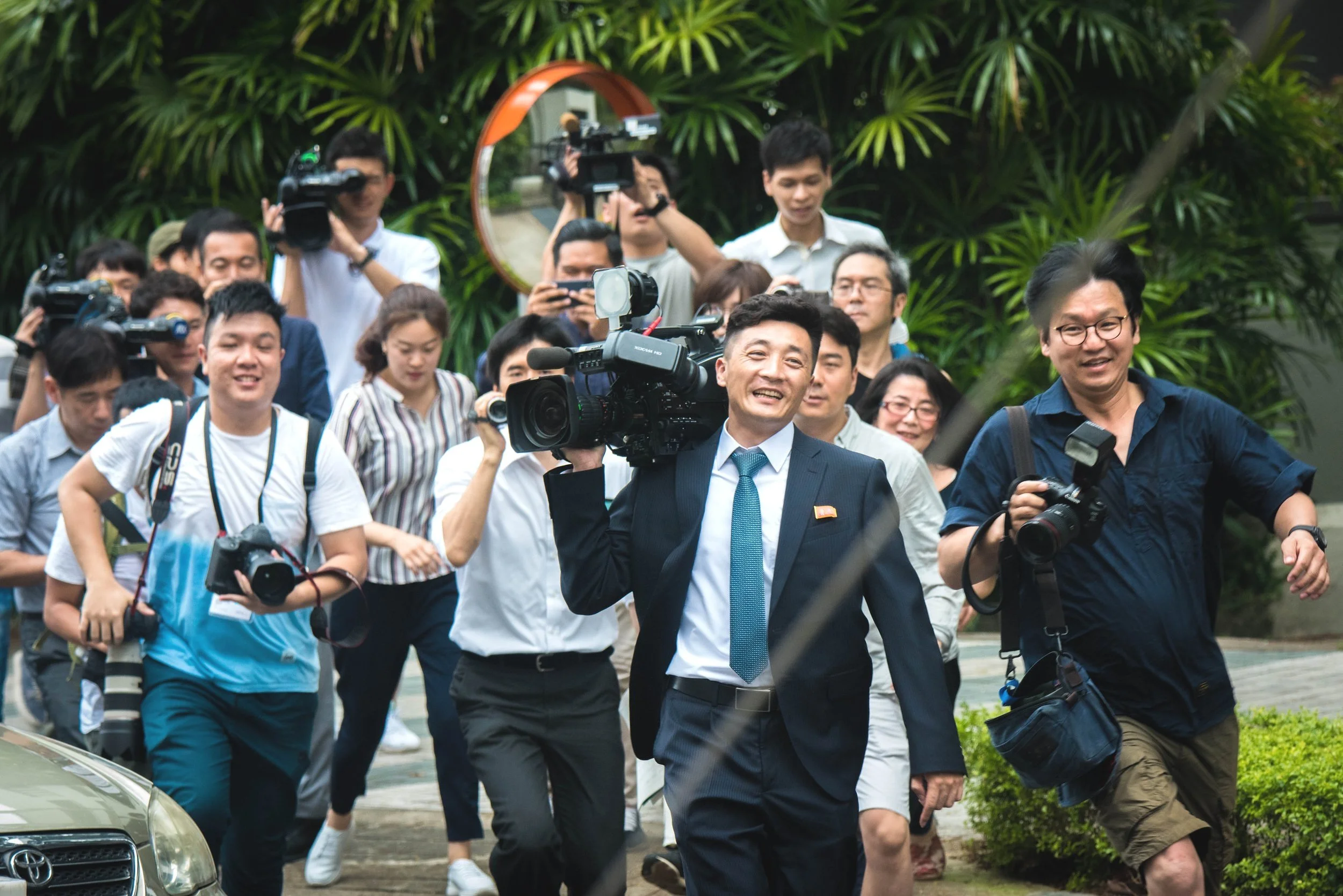 A pool of journalists swarming around the rare sight of a North Korean media official while awaiting the arrival of North Korean supreme leader Kim Jong-un outside the vicinity of St. Regis hotel for the 2018 North Korea–United States Singapore Summi