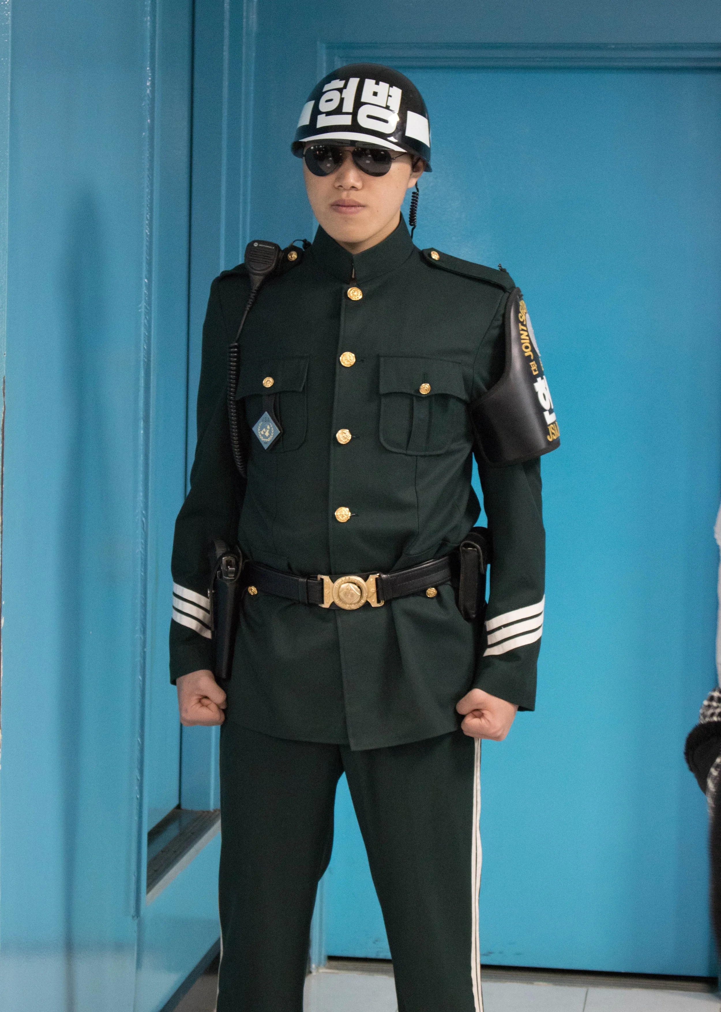 A South Korean military personnel guards the door behind him, a path that leads to North Korea.