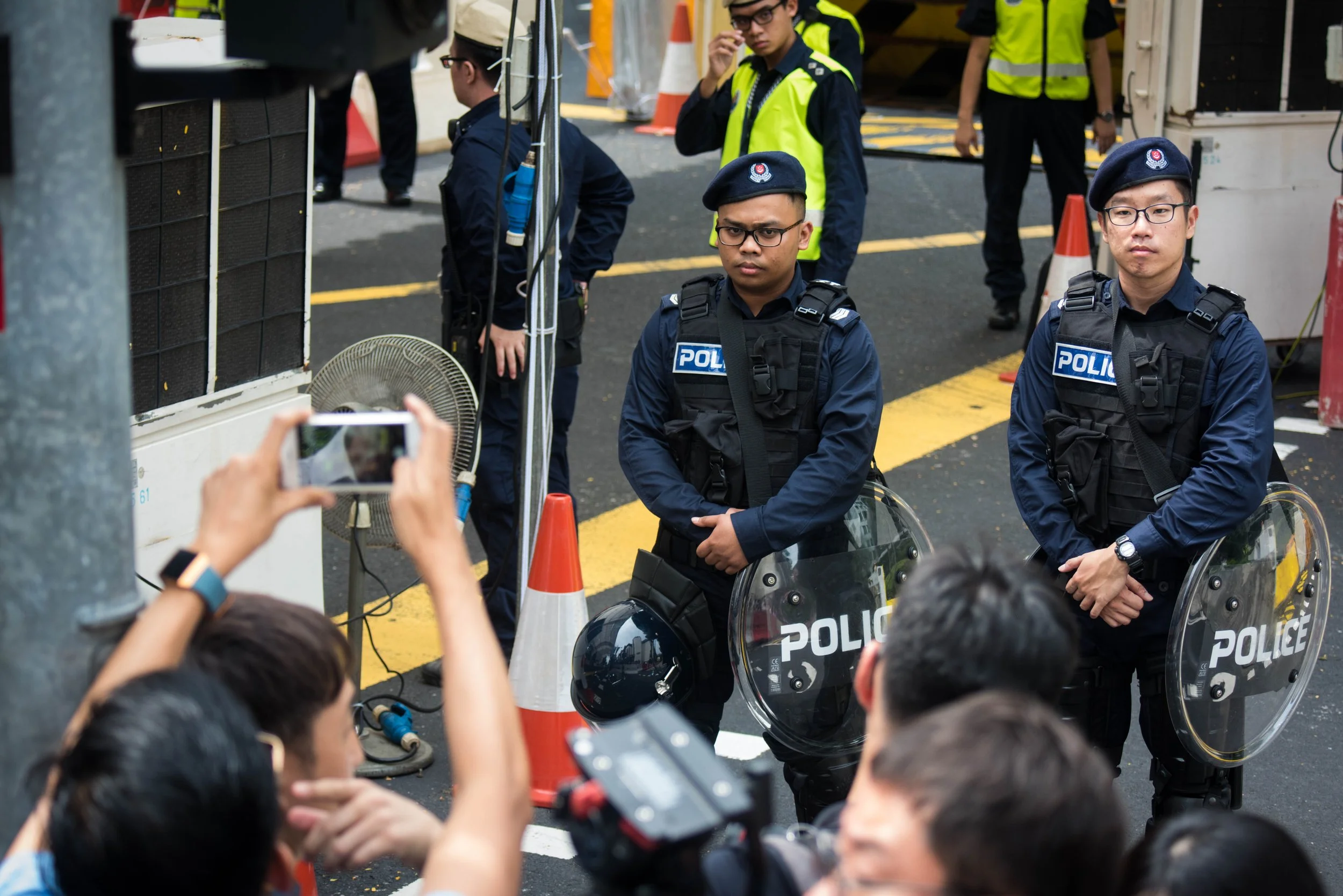 Singapore Police Force officers monitoring the media crowd while they await the arrival of North Korean supreme leader Kim Jong-un outside the vicinity of St. Regis hotel on 10 June, 2018.