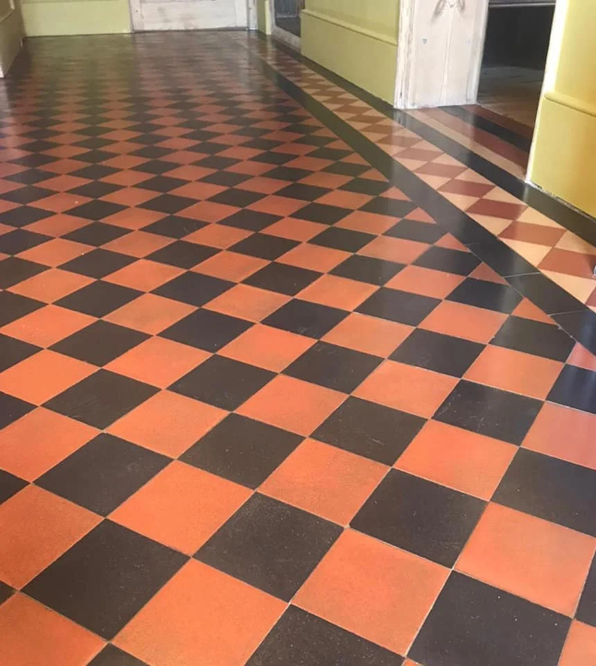 Checkerboard floor illusion creating a wavy effect in a hallway with beige walls.