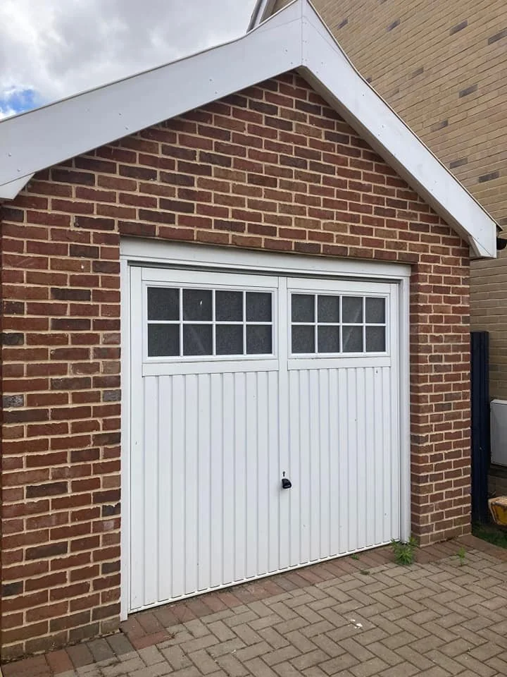 Brick garage with white door and windows