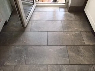 Gray ceramic tile floor in a room with an open door