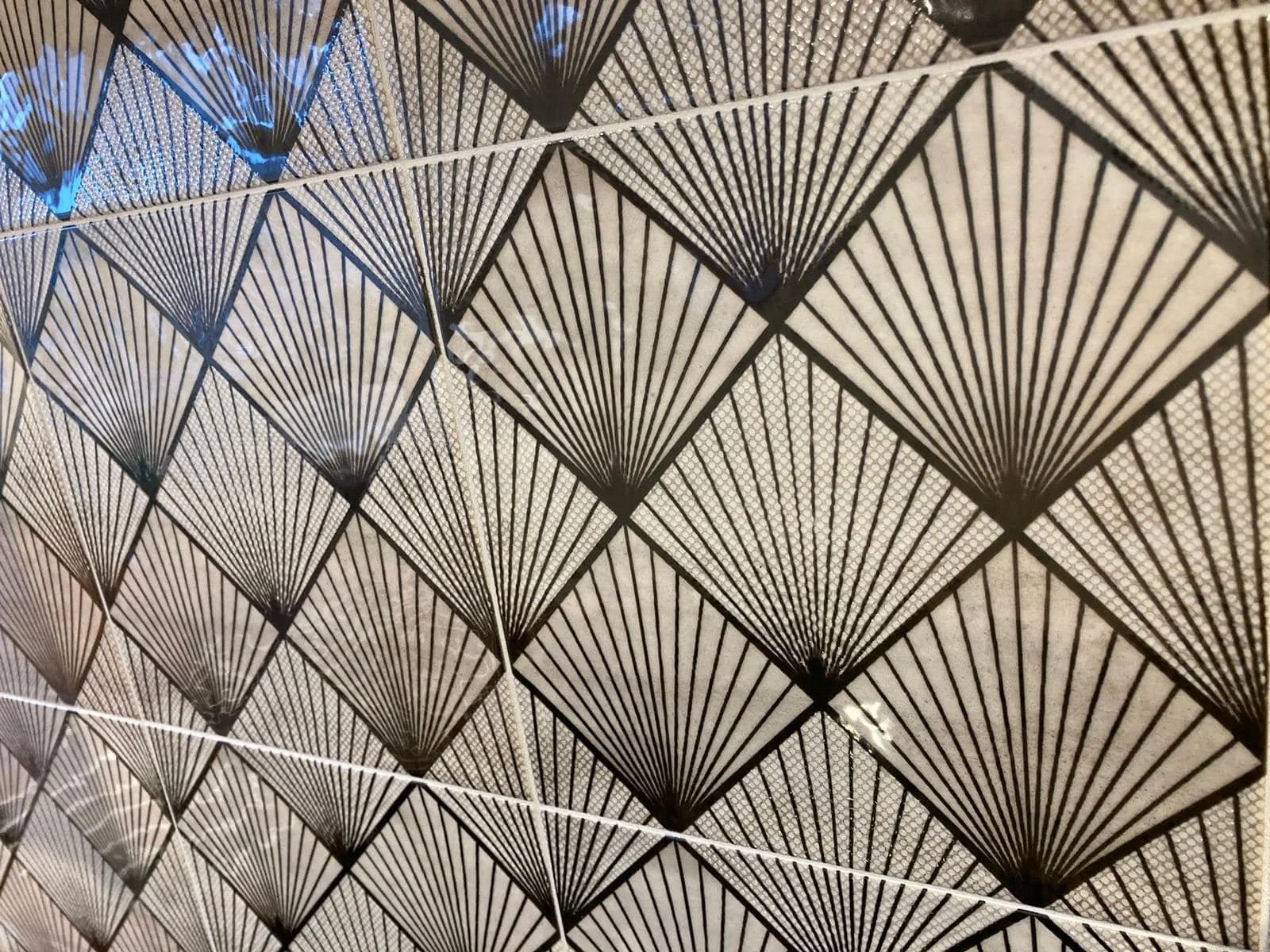 Geometric pattern of black fan-shaped designs on a light background