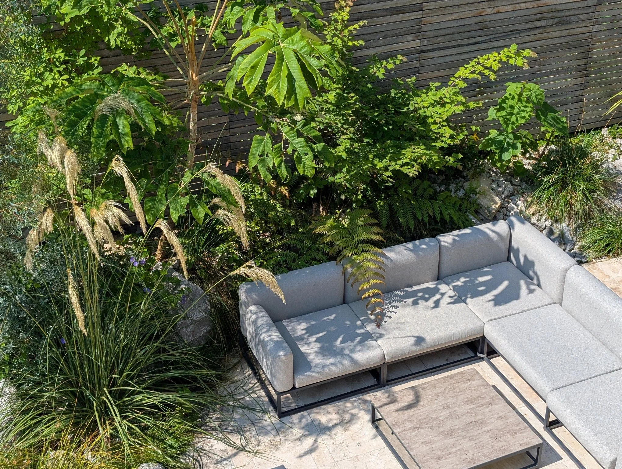 Aménagement paysager contemporain à Paris par Simonson Landscape, avec terrasse élégante, végétation dense et approche de bureau d’étude paysagiste