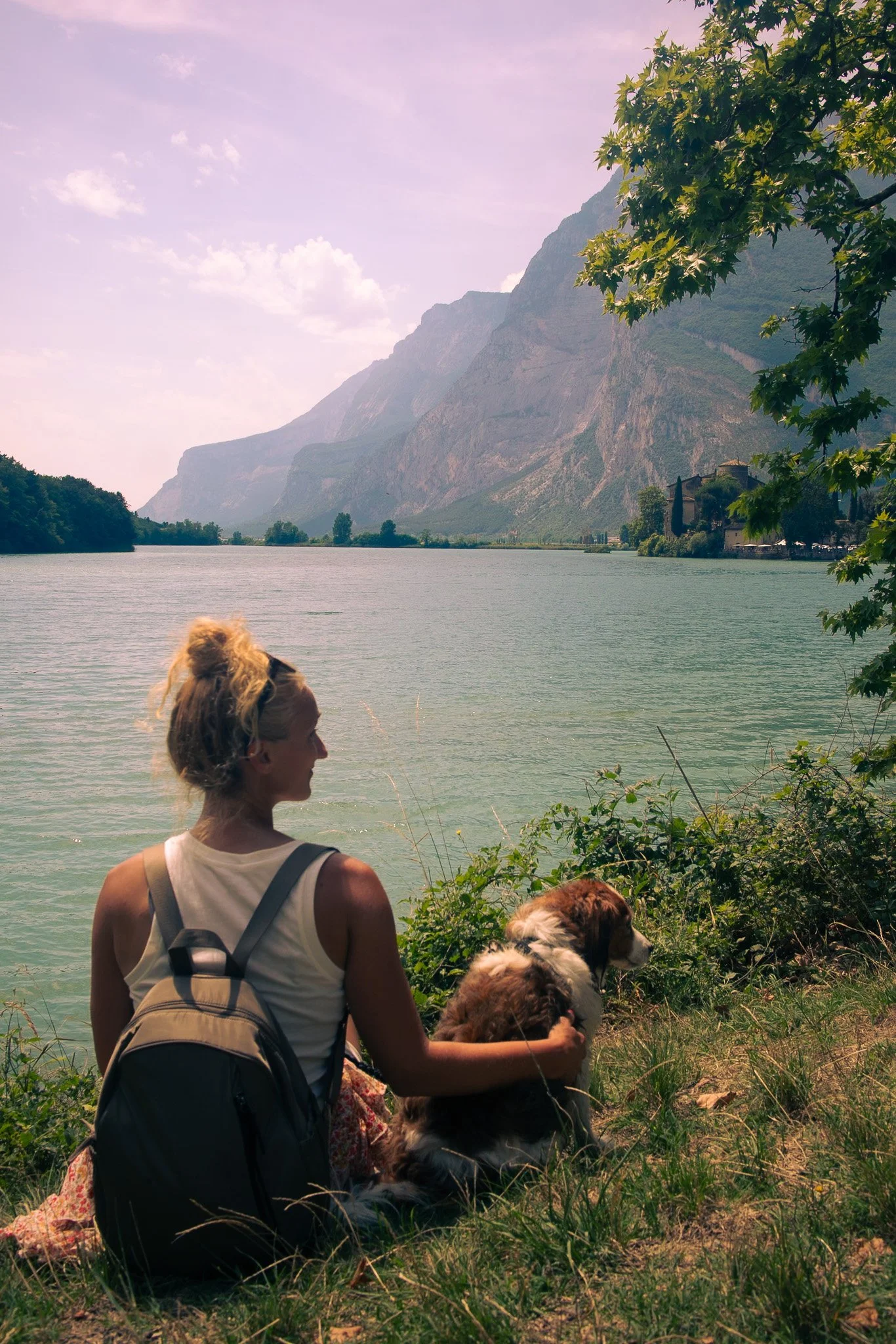 Woman and her dog sitting by an Italian lake
