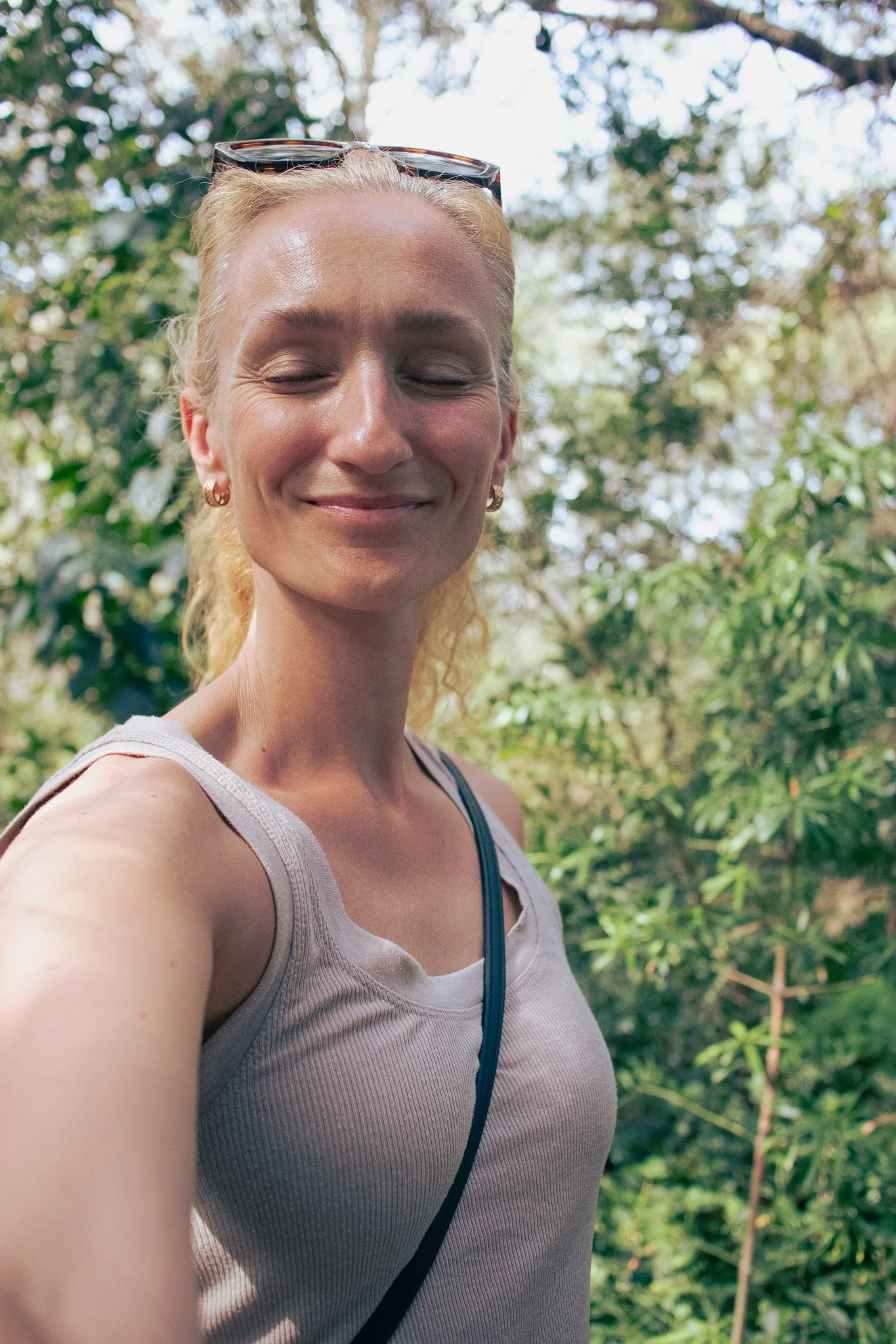 Woman looking relaxed and smiling with closed eyes in nature