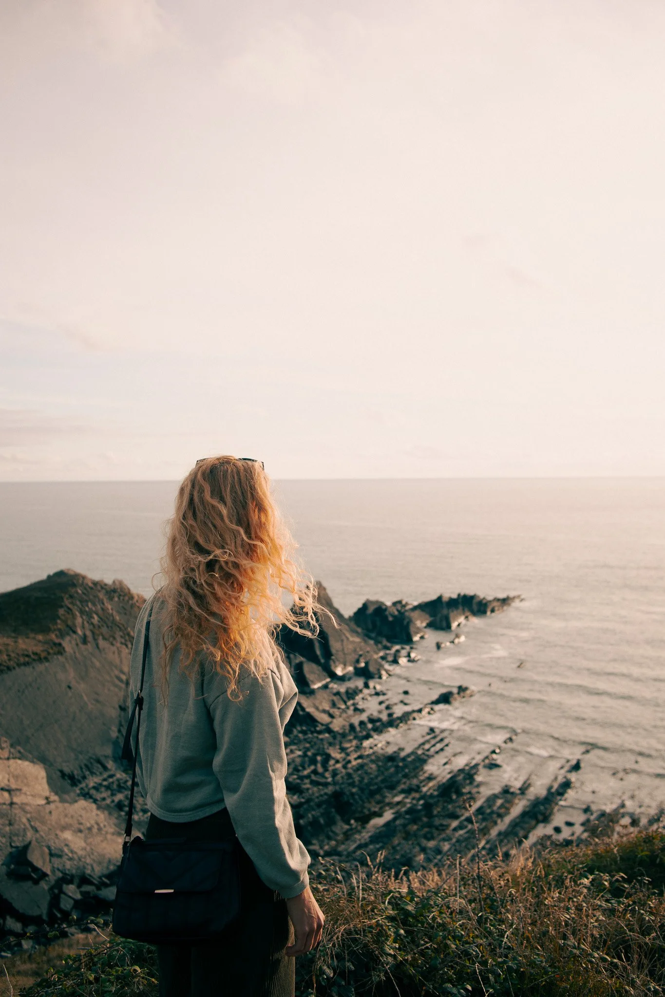 Woman looking out on the sea and cliffs in England
