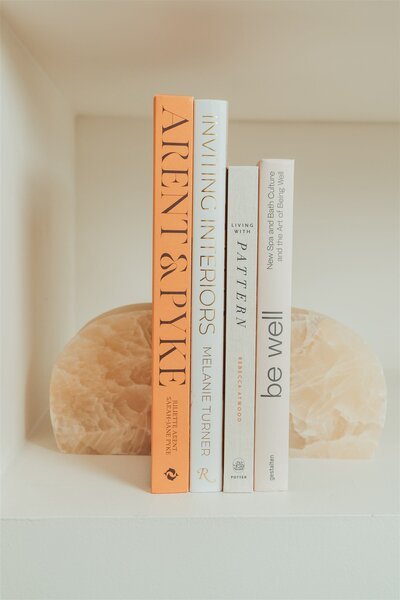 Delicate rose quartz bookends on a bookshelf, adding a touch of elegance and refinement to the display.