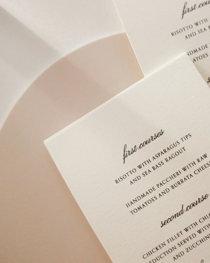 Whispers of white and the faintest blush &mdash; a custom-embossed menu designed to reflect the softness and serenity of the day.

Every curve, every pressed letter, every nuanced hue was chosen not just to complement the table, but to elevate the en