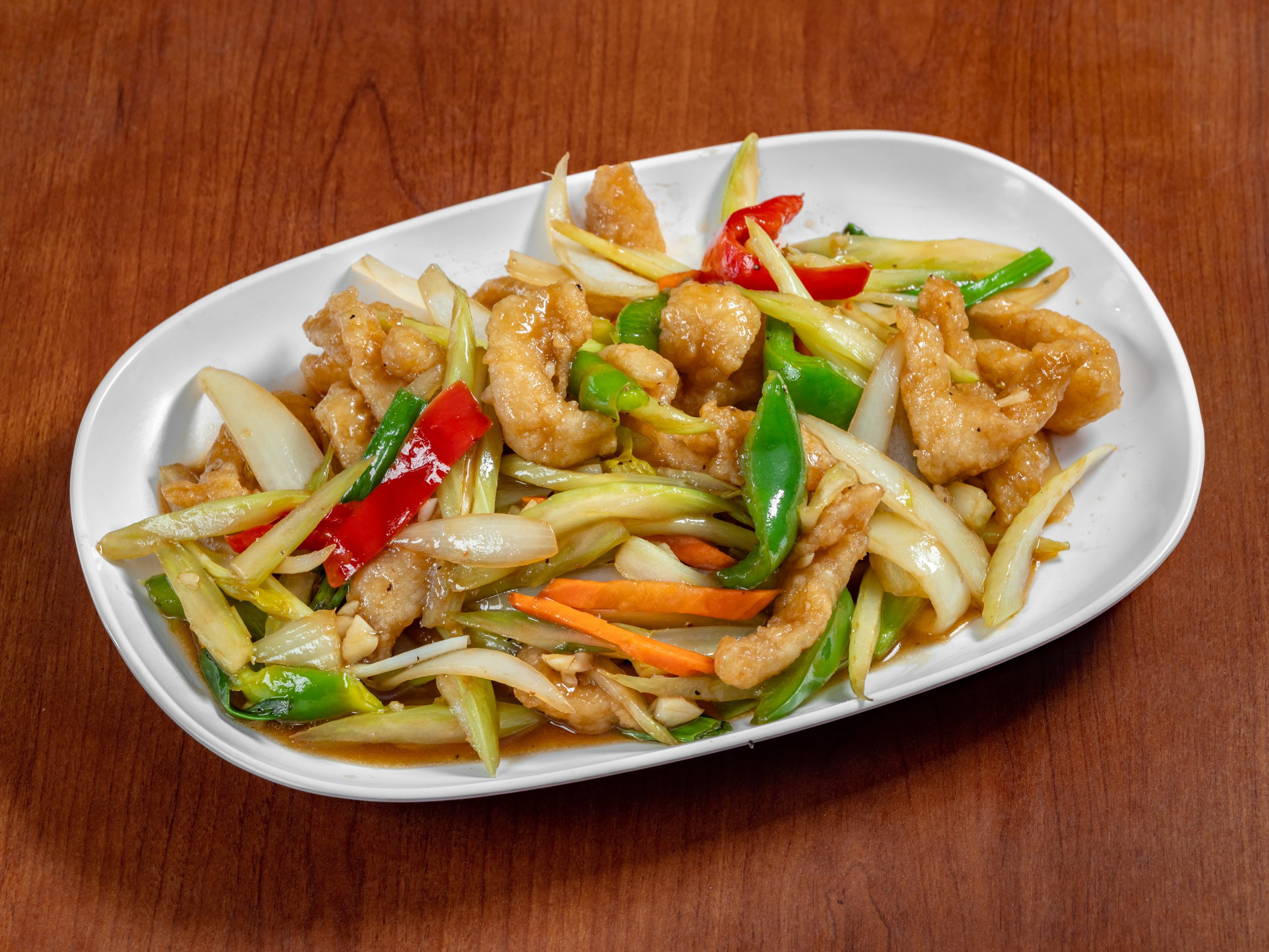 Cashew chicken stir-fried with roasted cashews, colorful bell peppers, onions, scallions, and tender chicken in a savory Thai-style sauce, served hot with fragrant jasmine rice.