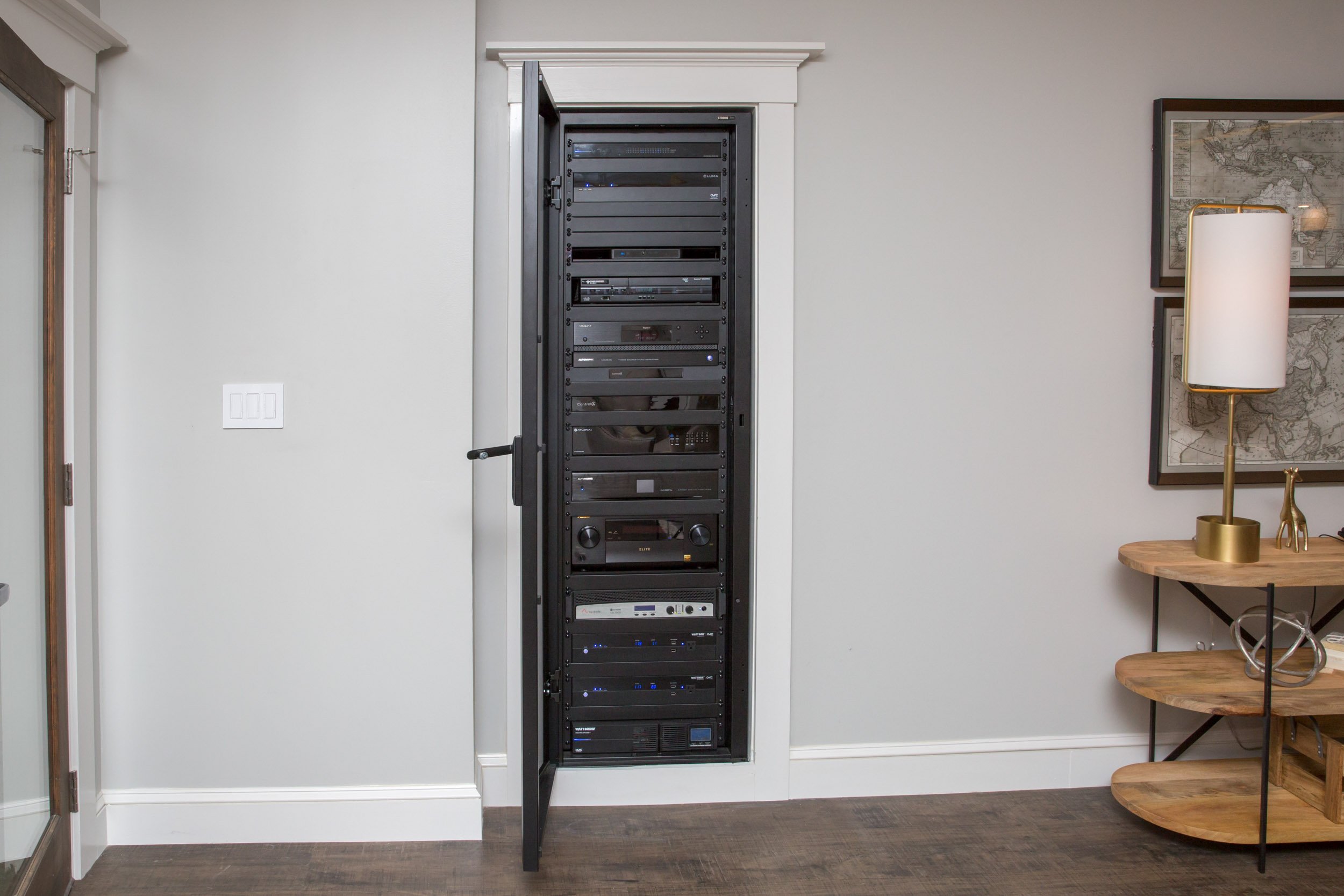 Network Equipment Rack with door encased in-wall with white trim surrounding the equipment