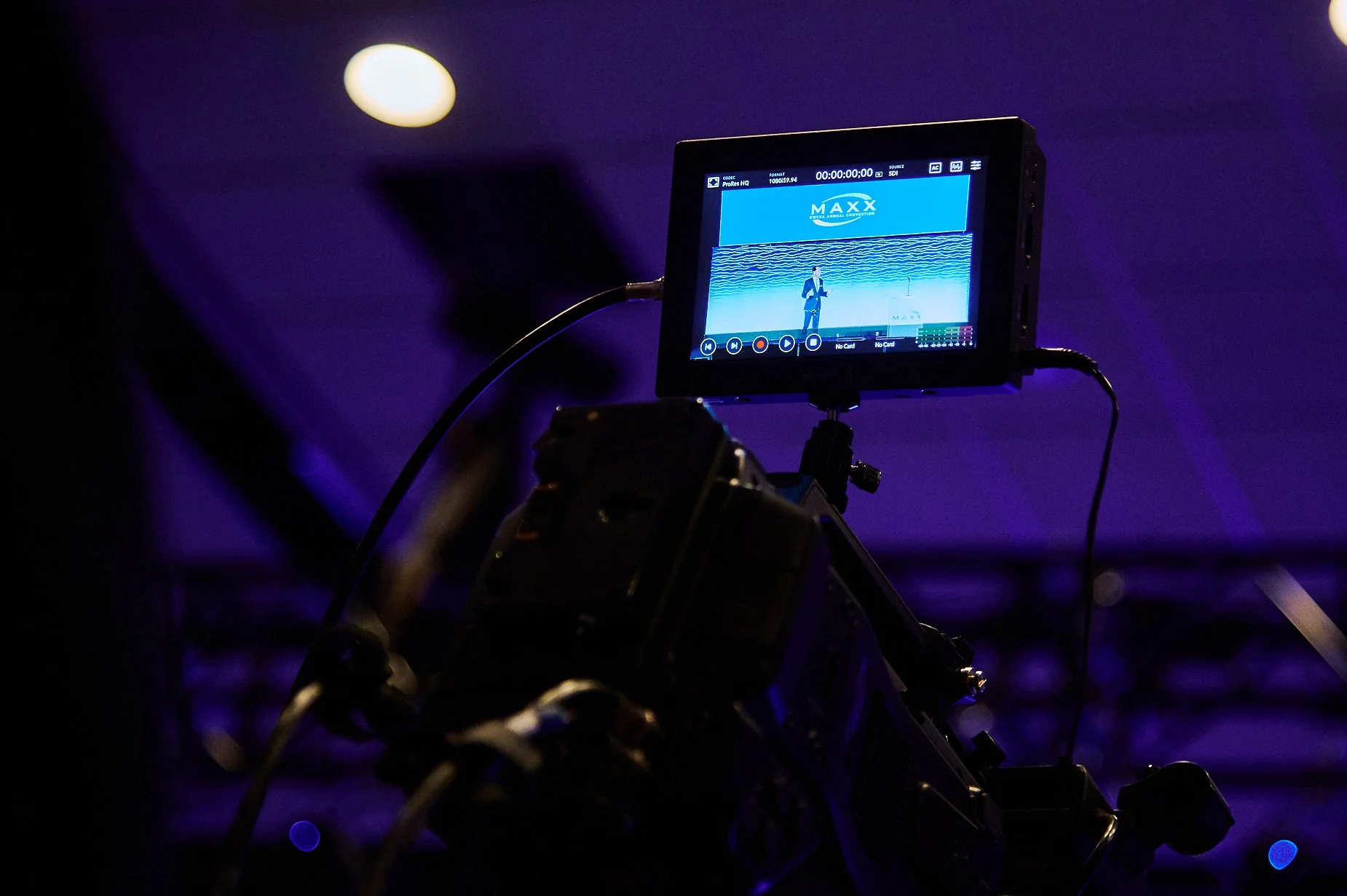Camera with monitor showing live event recording in dimly lit environment