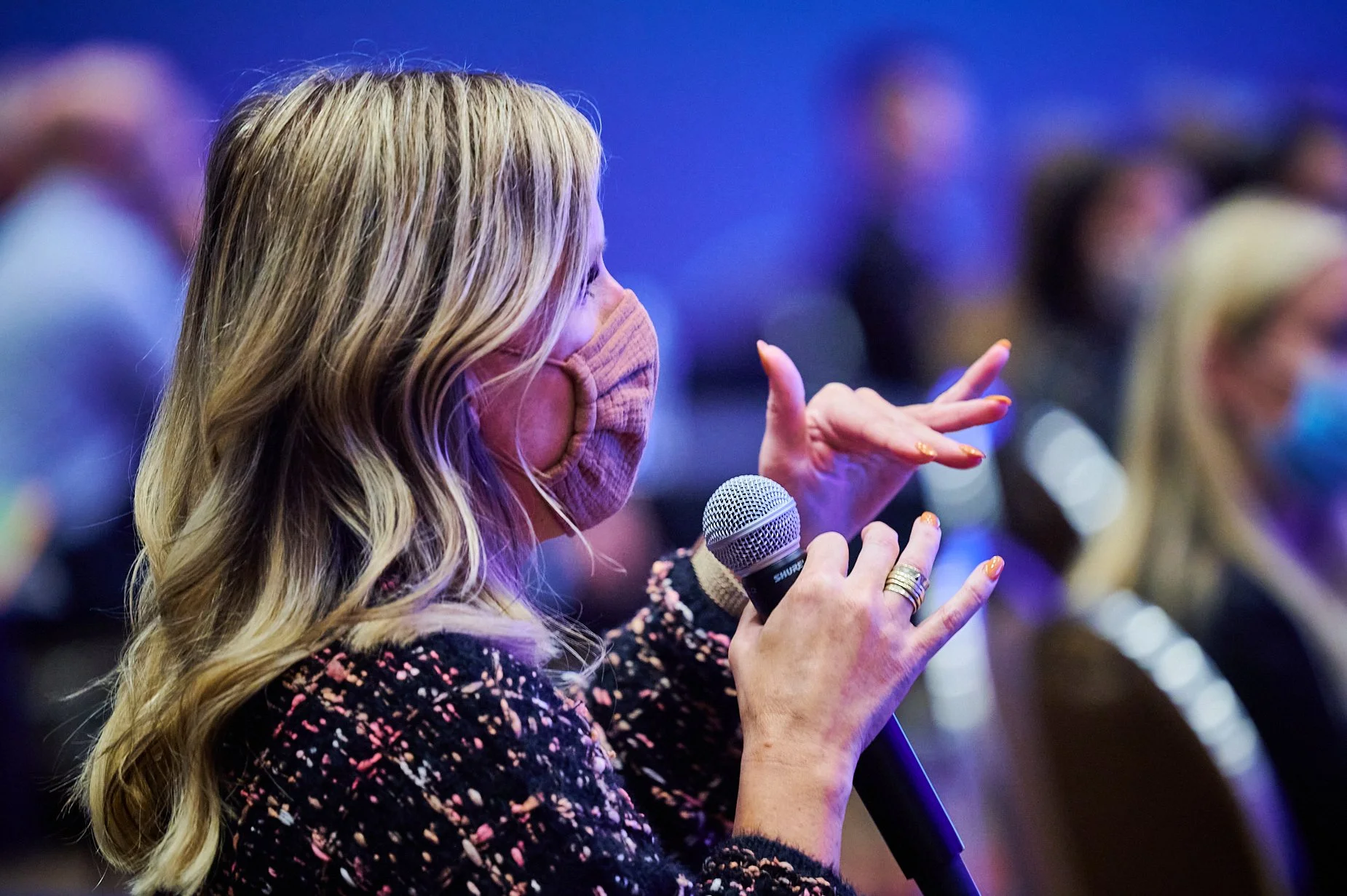 Person with mask holding a microphone during an event