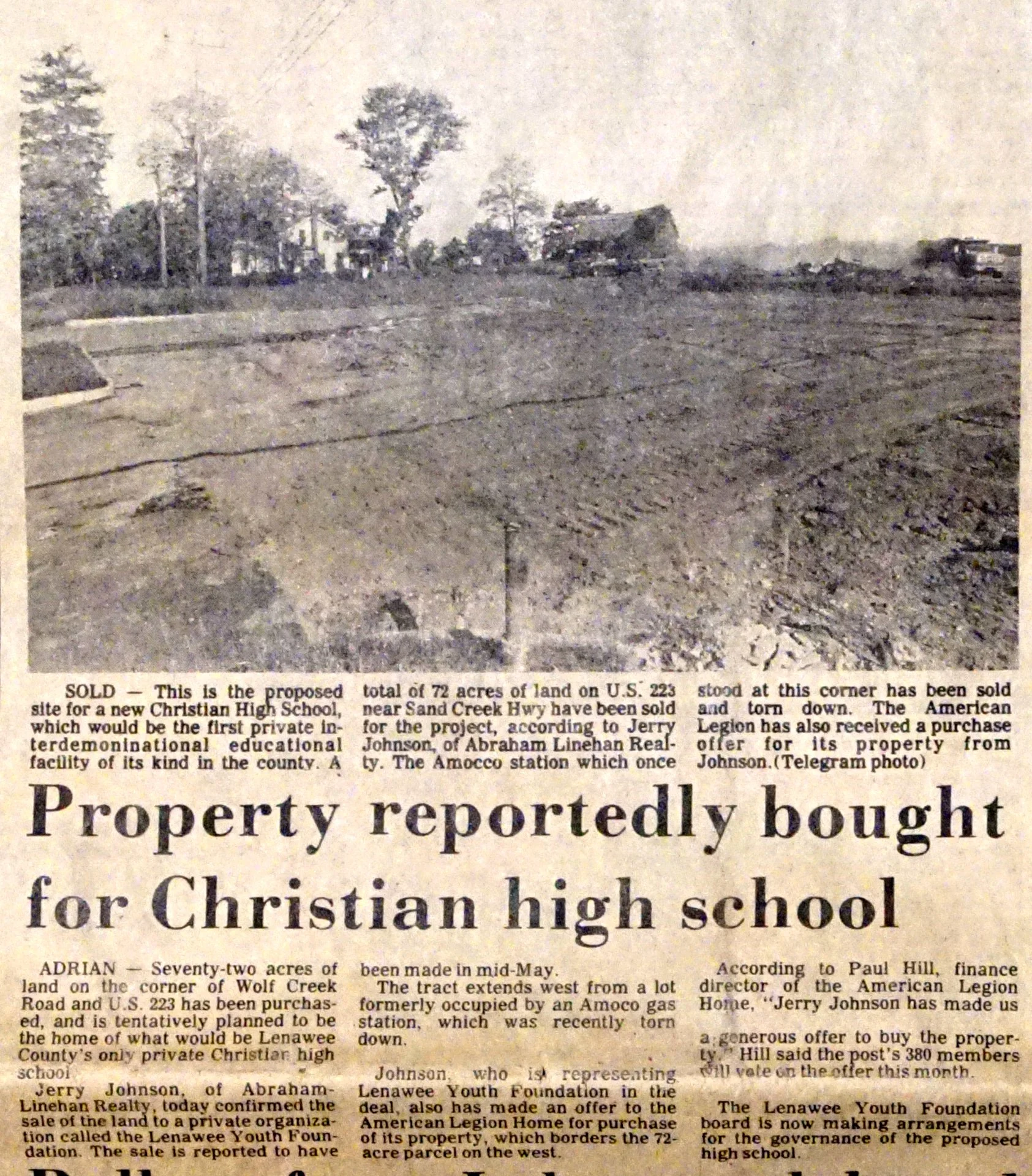 A black and white newspaper clipping about land sale for Christian high school, showing dirt land with some trees and distant buildings.