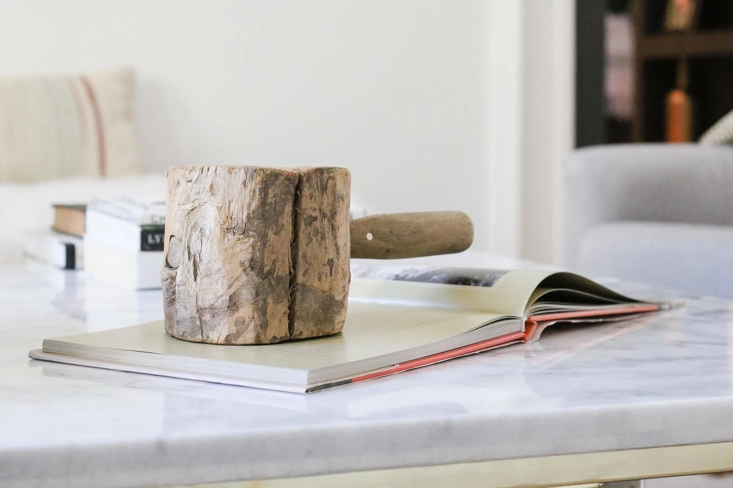 Adding cool/fun objects as paperweights on coffee table books can help elevate the decor while simultaneously providing a functional aesthetic. Here, we&rsquo;ve styled an HofR found vintage wooden hammer for an eclectic aesthetic. Coming soon on Hou