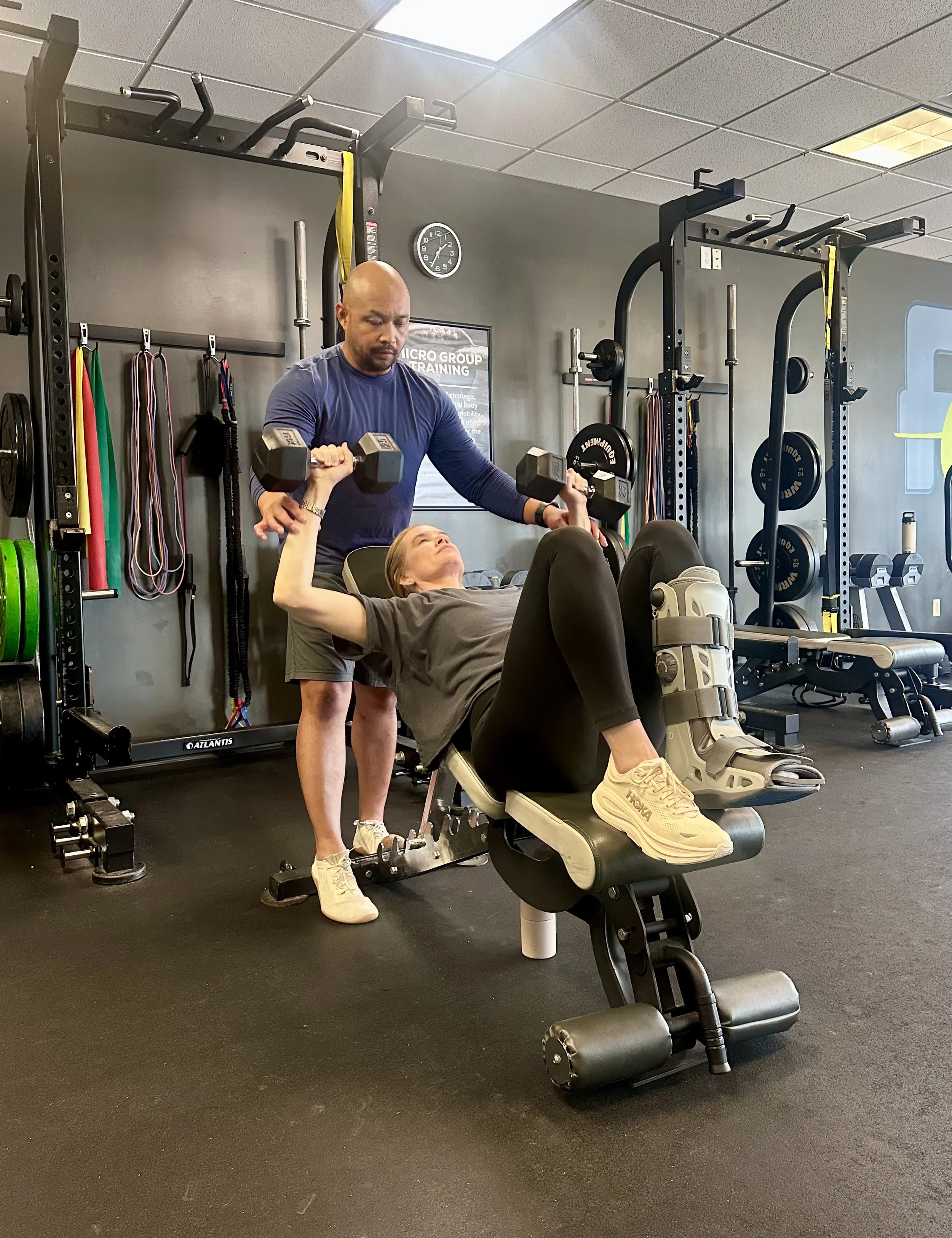 Woman over 40 performing a dumbbell chest press with coaching during a personal training session to build strength and support healthy aging