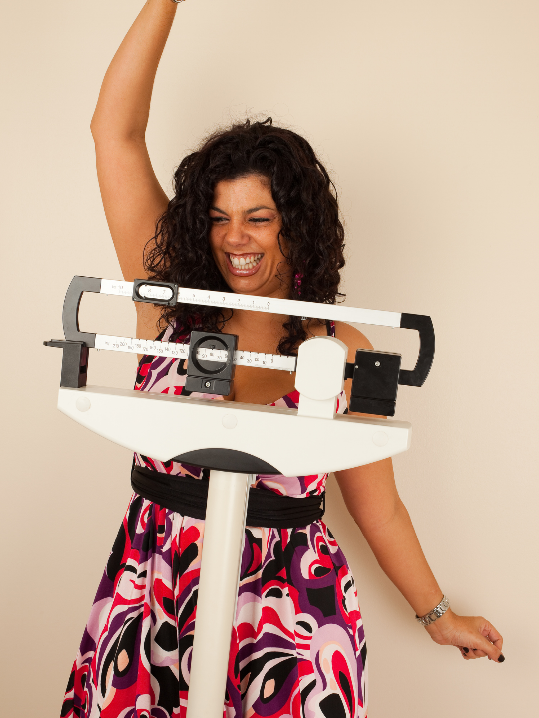 Woman celebrating successful weight loss while standing on a physician's scale
