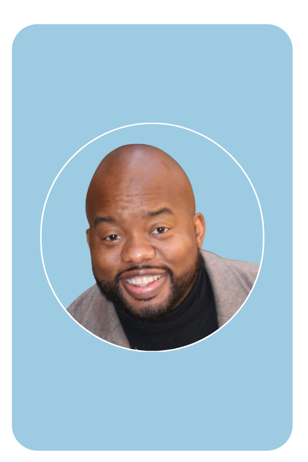 Smiling man with a beard and bald head wearing a coat and a black shirt on a black background.