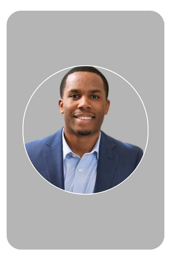 Smiling man in a blue suit and light blue shirt against a dark background.
