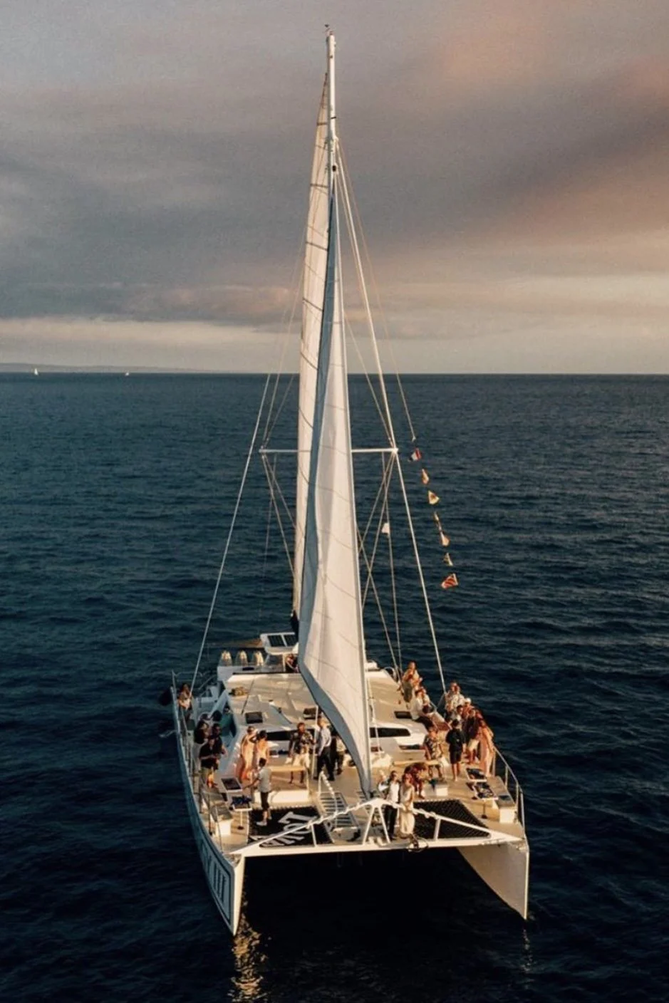 An aerial view of a small wedding on a private charter at sunset.