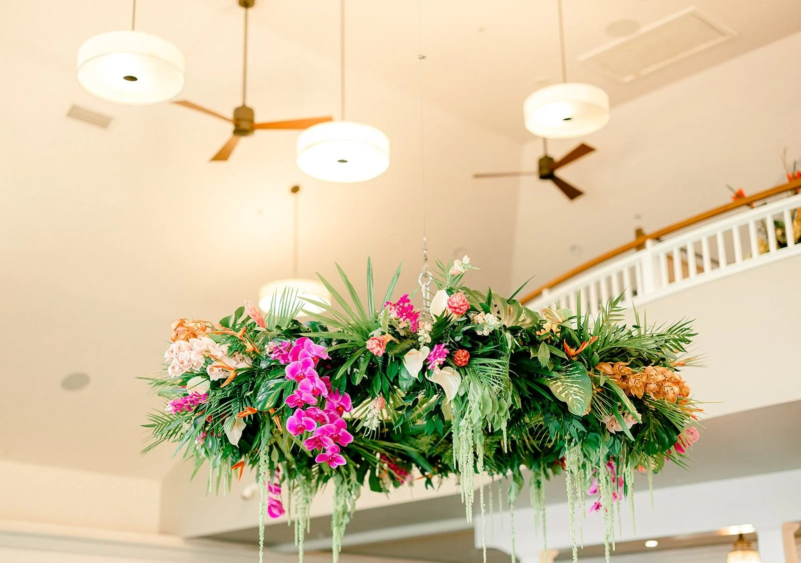 A hanging floral install at a bright interior wedding reception