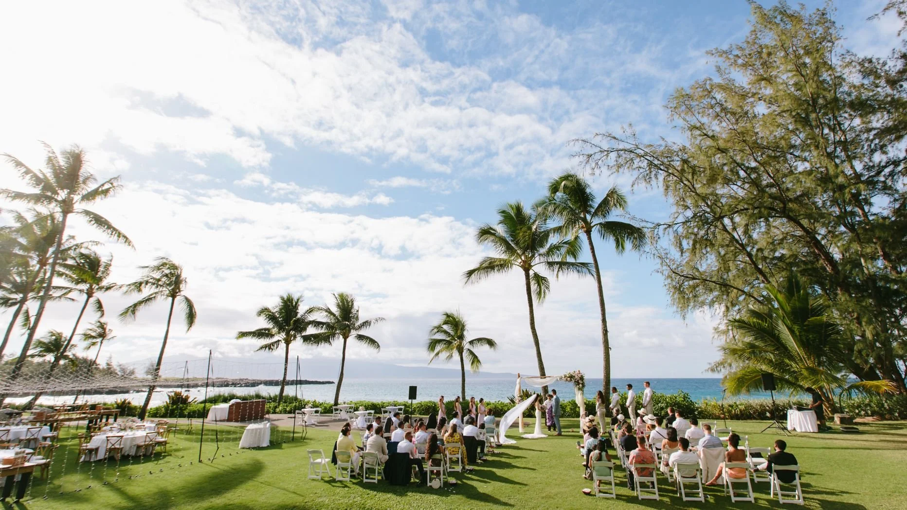 An outdoor oceanside wedding ceremony on the grass.