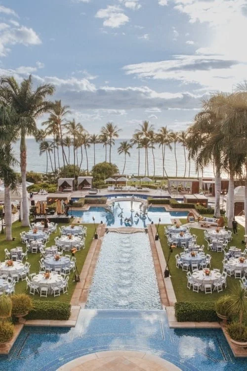 An aerial view of an outdoor Grand Wailea wedding reception with the ocean in the distance